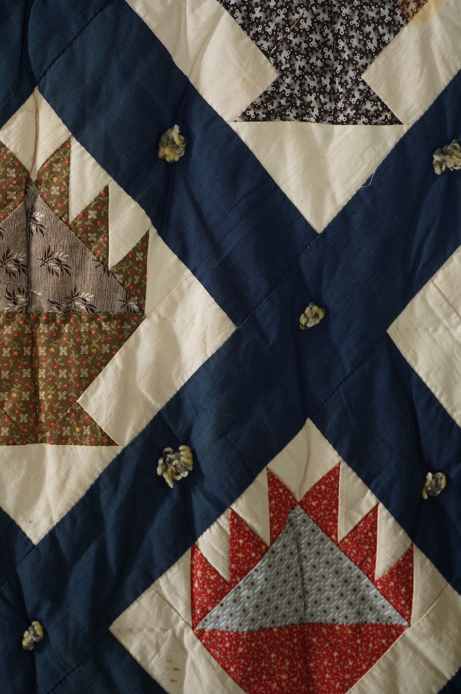 A bold handsome, American, Vermont 1865 (Civil War) ‘basket’ and lattice, hand quilted and piece tied bedcover, with an ornate floral backing. Worked with a plain navy cotton lattice border around central stylised printe